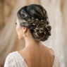 Bride's elegant updo from behind showing intricate twisted sections secured with bobby pins and pearl earrings
