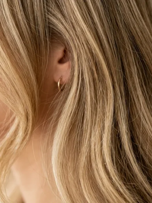 Woman with butter blonde balayage highlights showing seamless color transition from roots to ends