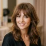 Woman with butterfly bangs showing soft layered fringe in professional salon lighting