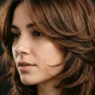Woman with butterfly haircut showing dramatic face-framing layers and wing-like movement around face