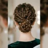 Woman with elegant curly updo viewed from behind showing twisted sections and bobby pin placement at nape