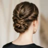 Close-up view from behind showing elegant updo with visible pin placement and twisted hair sections at nape of neck