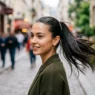 Woman with mirror-shine sleek ponytail in natural daylight showing glass hair texture
