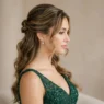 Young woman with half up prom hairstyle featuring pulled back sections and loose face-framing pieces