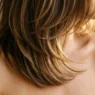 Woman with shoulder-length layered hair showing subtle graduation and movement with golden side lighting