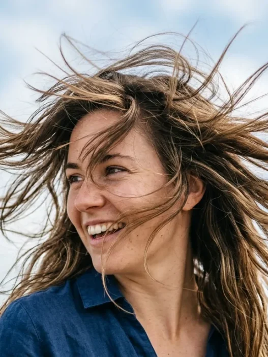 Woman with mid-length wavy hair caught in motion by gentle breeze showing natural texture and movement