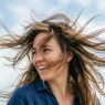 Woman with mid-length wavy hair caught in motion by gentle breeze showing natural texture and movement