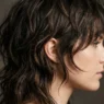 Woman with modern shaggy mullet showing textured layers from jawline to crown in studio lighting