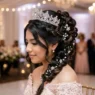 Quinceañera with elaborate braided updo and crystal tiara showing intricate pearl hair details