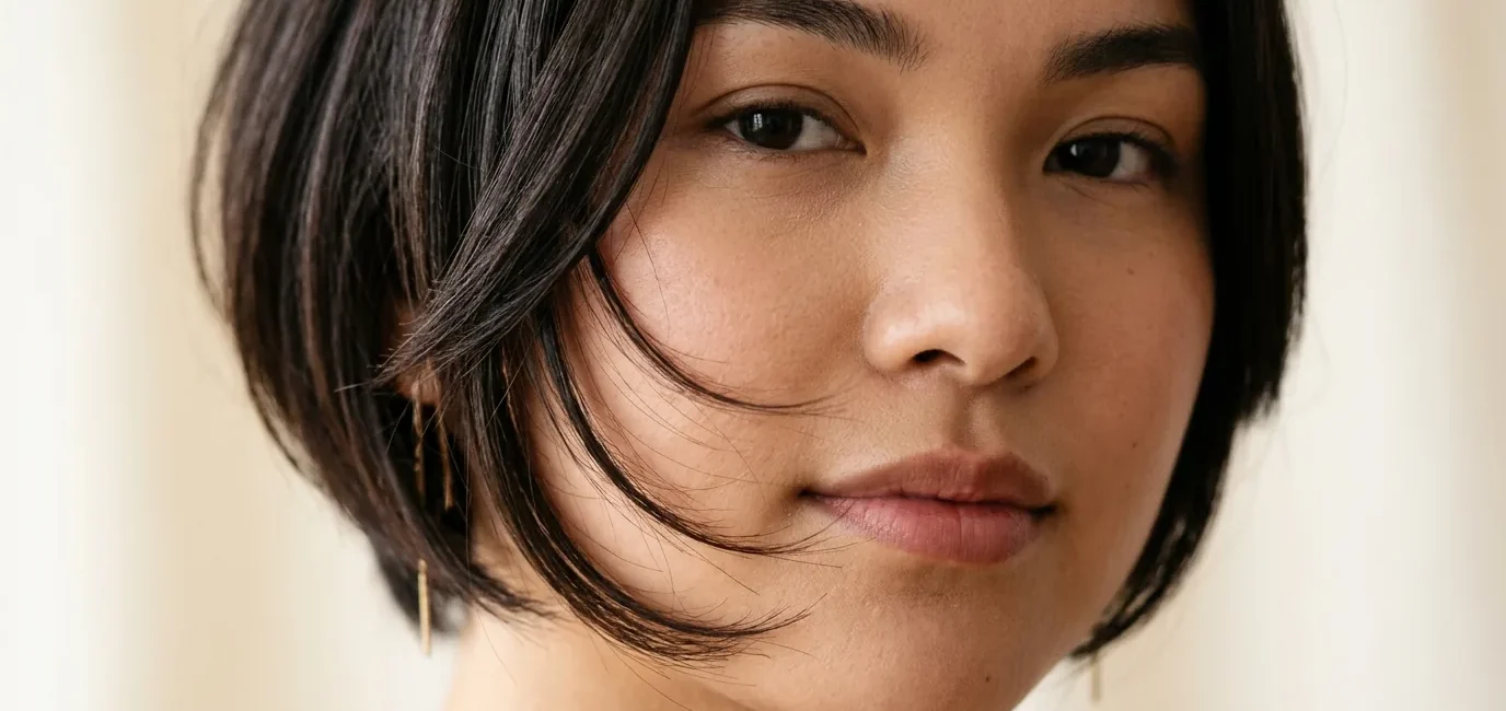 Woman with round face showing perfectly angled bob with forward-sloping face-framing layers that extend past jawline