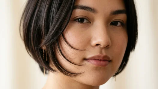 Woman with round face showing perfectly angled bob with forward-sloping face-framing layers that extend past jawline