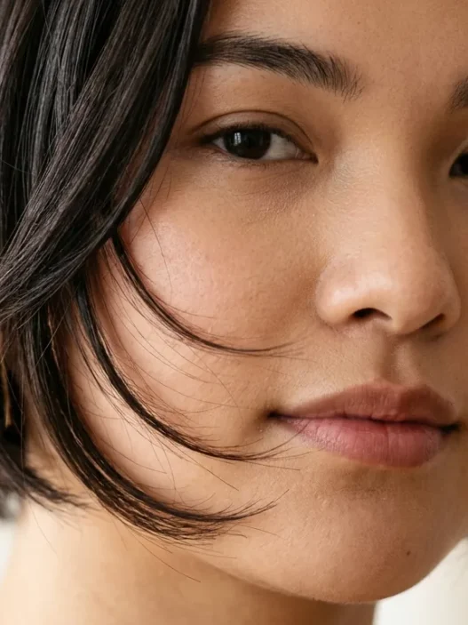 Woman with round face showing perfectly angled bob with forward-sloping face-framing layers that extend past jawline