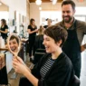 Woman experiencing joy seeing her new short haircut for the first time in salon mirror