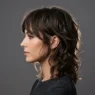 Woman with layered shaggy haircut showing textured movement in side profile studio shot