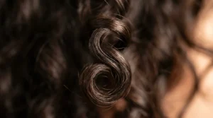 Close-up macro view of defined wave pattern in short hair showing natural curl structure and light reflection