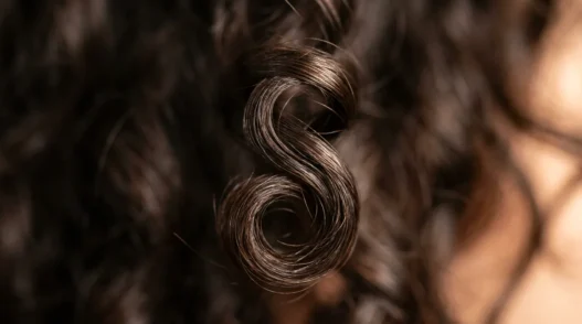 Close-up macro view of defined wave pattern in short hair showing natural curl structure and light reflection