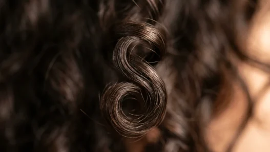 Close-up macro view of defined wave pattern in short hair showing natural curl structure and light reflection
