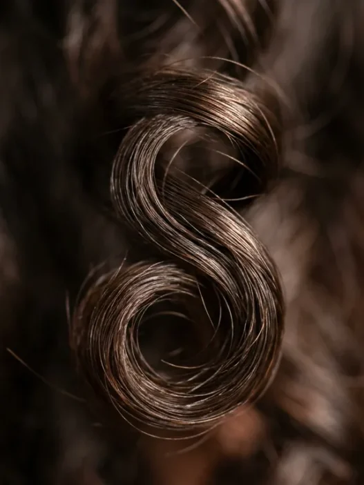 Close-up macro view of defined wave pattern in short hair showing natural curl structure and light reflection