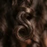 Close-up macro view of defined wave pattern in short hair showing natural curl structure and light reflection