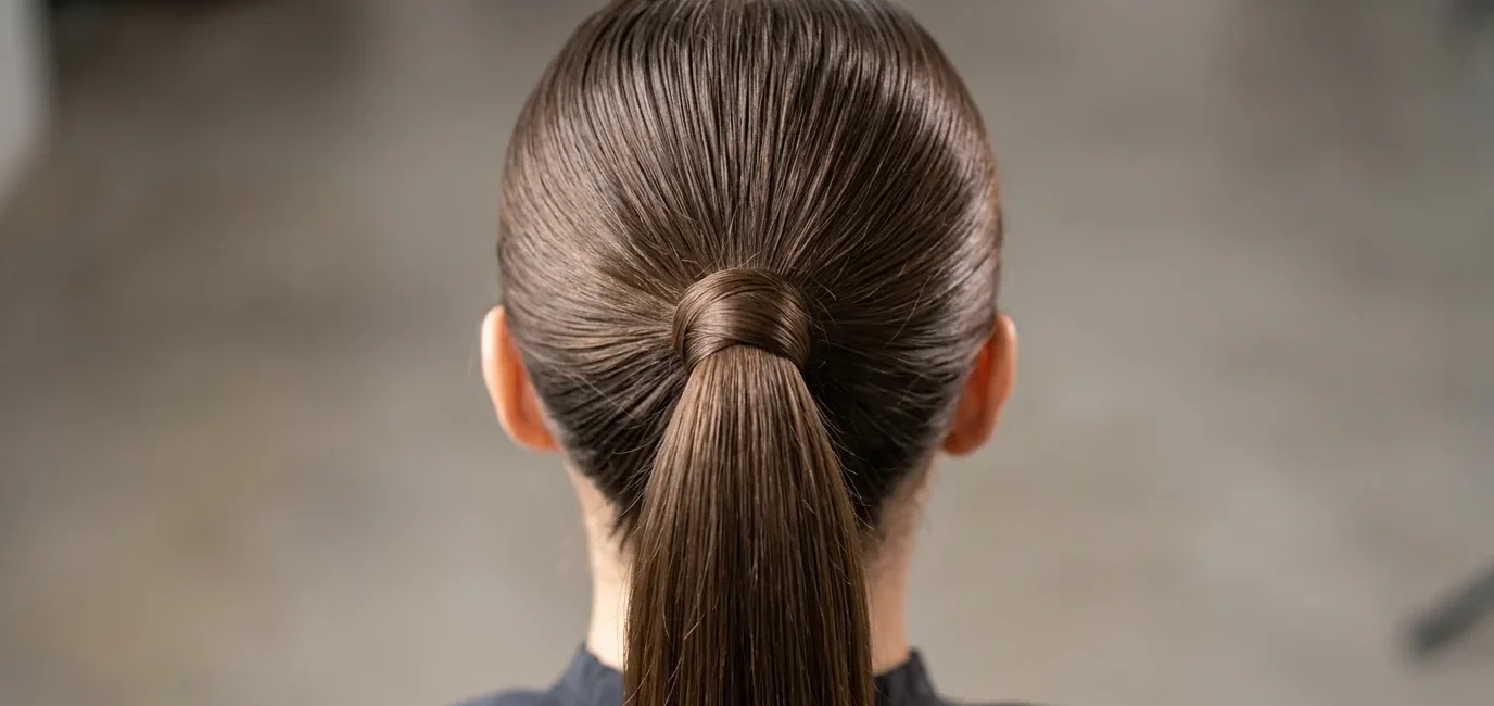 Close-up view of sleek ponytail base showing hair gathering technique and wrapped elastic detail