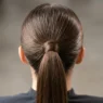 Close-up view of sleek ponytail base showing hair gathering technique and wrapped elastic detail
