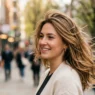 Woman showing spring hairstyle trends in natural street style photography with wind movement