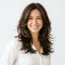 Woman with beautifully styled layered hair showing natural movement and volume in bright lighting