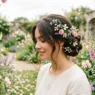 Woman with elegant updo hairstyle in blooming garden setting with natural lighting and wildflowers