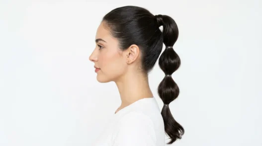 Woman showing completed bubble ponytail with multiple defined sections in side profile