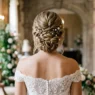 Elegant bridal bun hairstyle from behind showing twisted updo with pearl hair pins