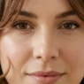 Woman with shoulder-length layered haircut designed for round face shape showing strategic angles