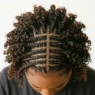 Overhead view of short curly hair styled in small braids mixed with loose curls showing pattern variety