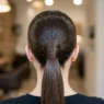Close-up view of sleek ponytail base showing hair gathering technique and wrapped elastic detail