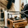 Extreme close-up of thinning shears cutting through layered hair ends with falling hair fragments