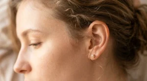 Close-up of delicate wispy hair tendrils and baby hairs at woman's temple area with soft lighting