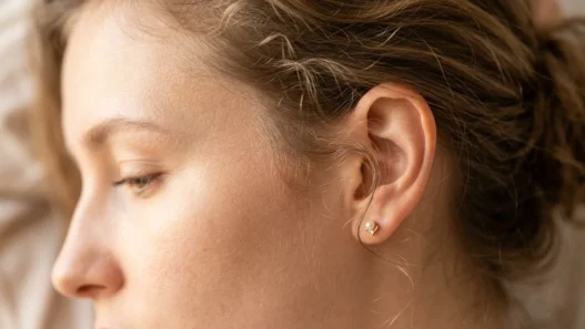 Close-up of delicate wispy hair tendrils and baby hairs at woman's temple area with soft lighting