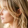Woman with wispy layered bangs showing soft texture and movement in blonde hair