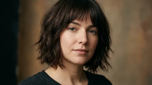 Woman with chin-length espresso brown shaggy bob showing feathered ends in soft light