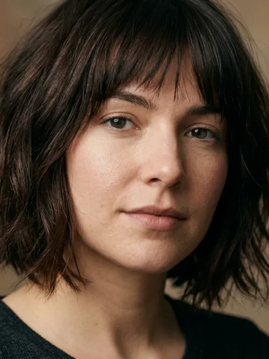 Woman with chin-length espresso brown shaggy bob showing feathered ends in soft light