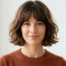 Woman with chin-length French bob and soft bangs in bright natural light