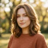Woman with shoulder length butterfly lob with soft layers glowing in golden hour light outdoors