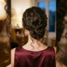 Woman with long dark curly hair in loose low twisted updo viewed from behind